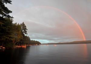 Color photography of a double rainbow over a lake.